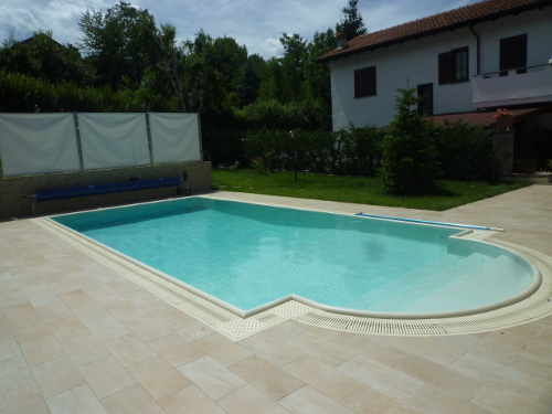 piscina a sfioro con canale perimetrale e gliglia in ABS colore sabbia come il rivestimento
